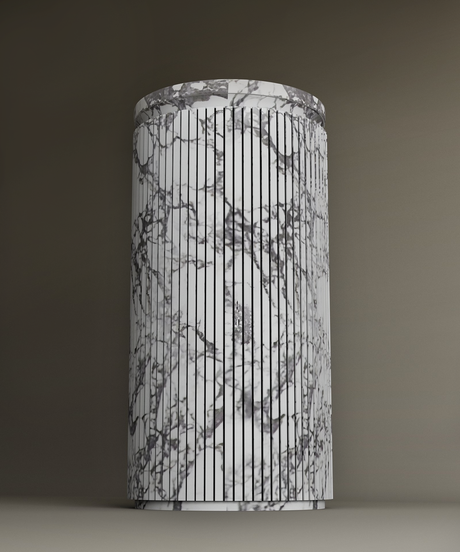 A rectangular marble box with black veining patterns sits on a gray surface. A single black-edged button is centered on the top of the box. The lighting creates a shadow on the left side.