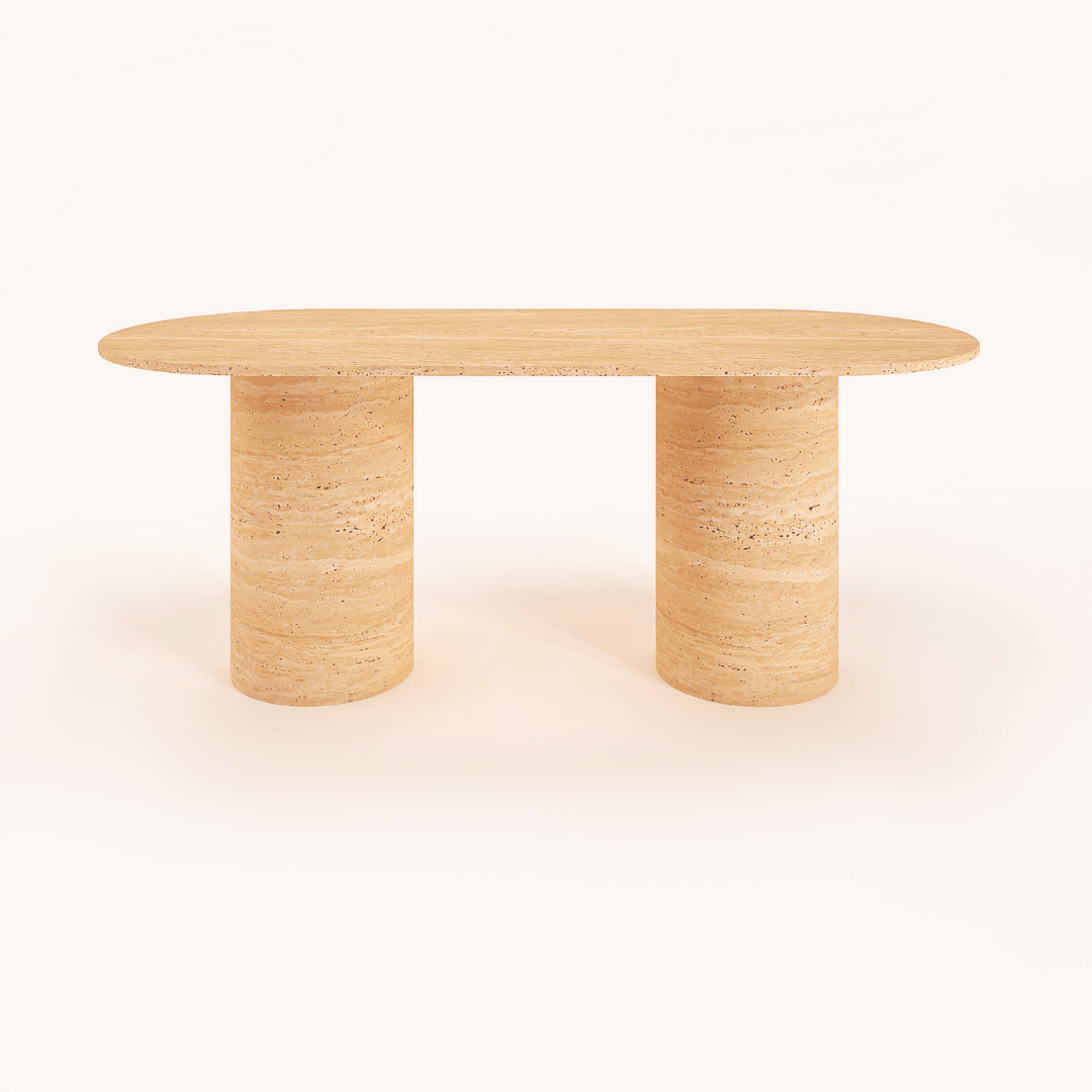 The Arcadia Dining Table by Travertable, an oval-shaped beige stone piece with a natural textured finish, features two cylindrical legs. Minimalistic and set against a white background, it can be customized to match any decor style.