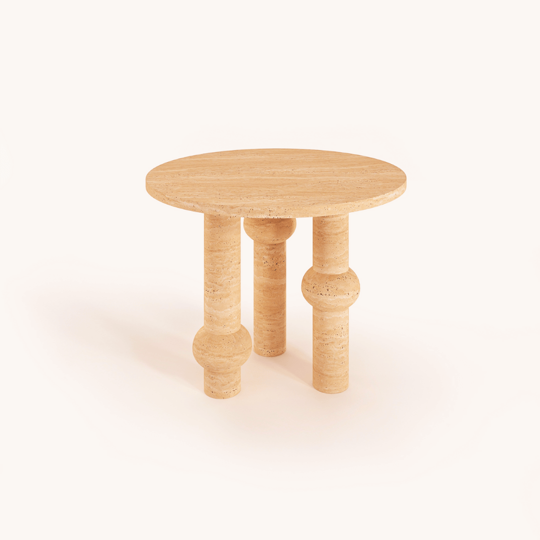 The Opulent Round Travertine Dining Table by Travertable features a textured surface and luxury appeal with three cylindrical legs accented by spherical details, creating a modern artistic look. A plain, neutral background highlights its elegance.