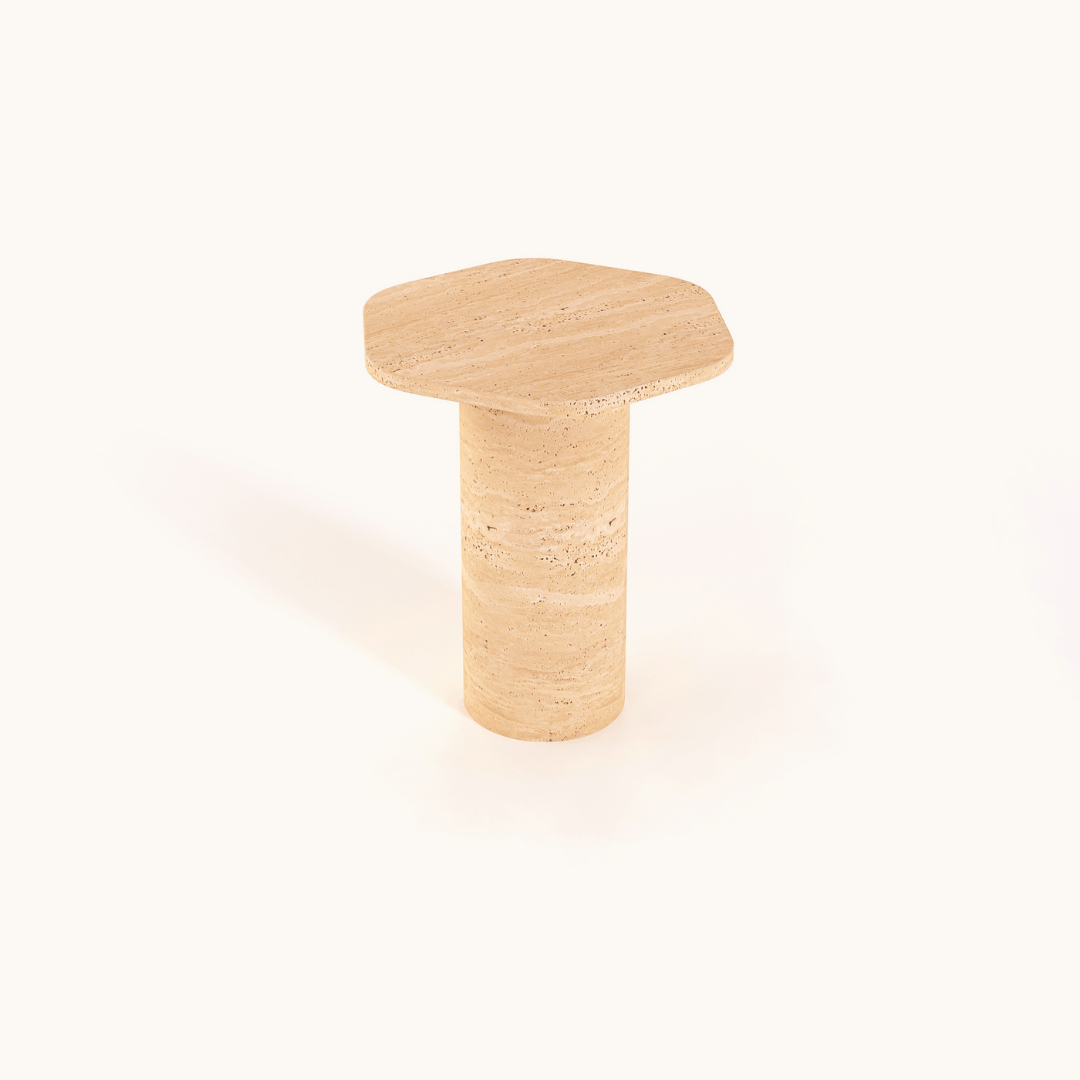 The Travertable Natural Beauty Travertine Side Table showcases an earthy elegance with its beige, hexagonal design and a handcrafted cylindrical base that mimics natural stone, all set against a plain white background.