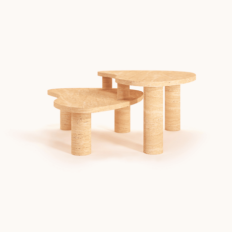 The Travertable Vintage-Inspired Travertine Coffee Table set, with contrasting designs and cylindrical legs, stands elegantly on a seamless background. The taller table creates a tiered effect, highlighting the organic veining and natural authenticity of their rounded tops.