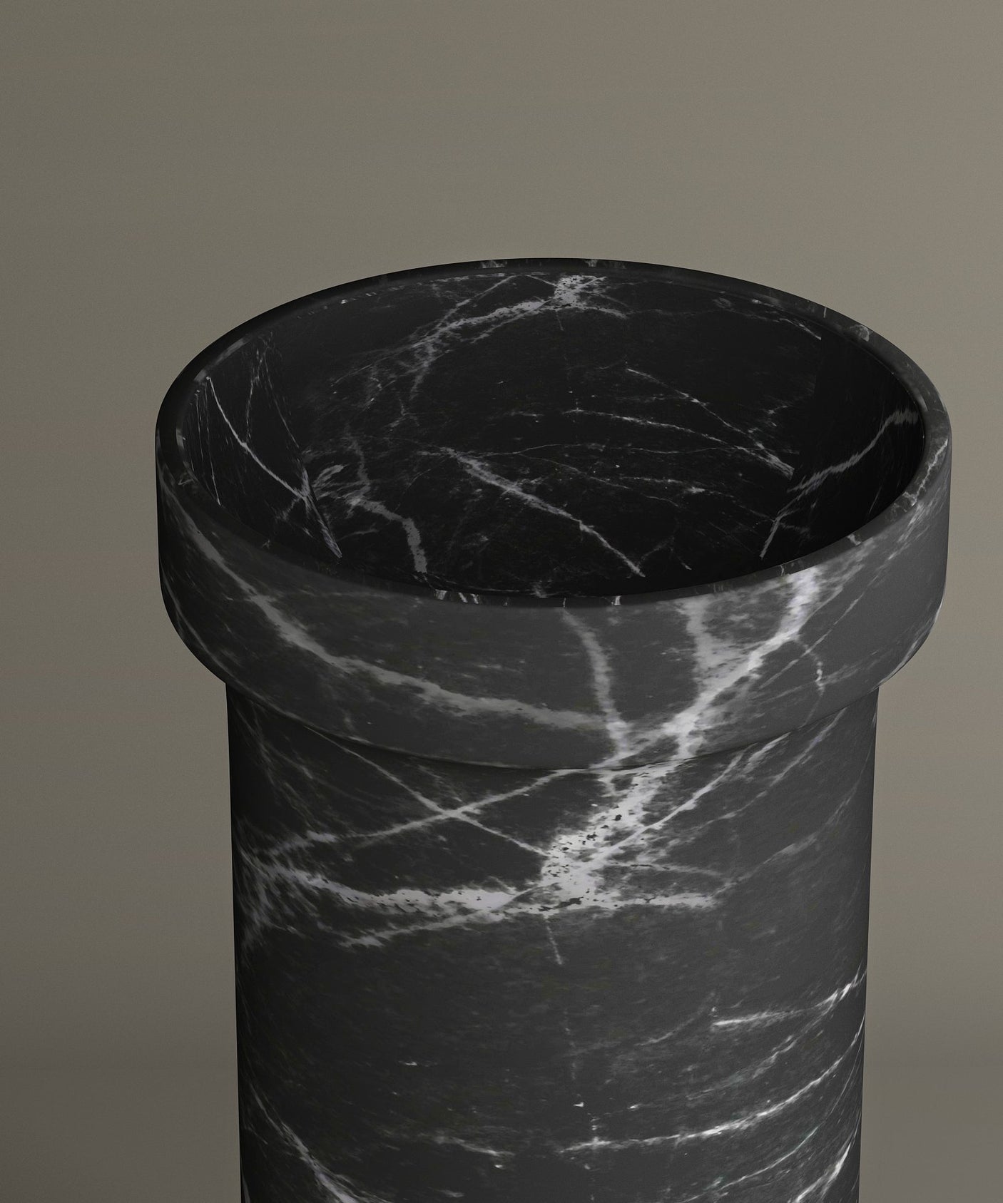 A close-up of the TRAVERTABLE Nero Marquina Marble Pedestal Vanity Sink, featuring bold white veining on black marble—its sleek cylindrical form stands out against a taupe backdrop, adding modern luxury to any interior.
