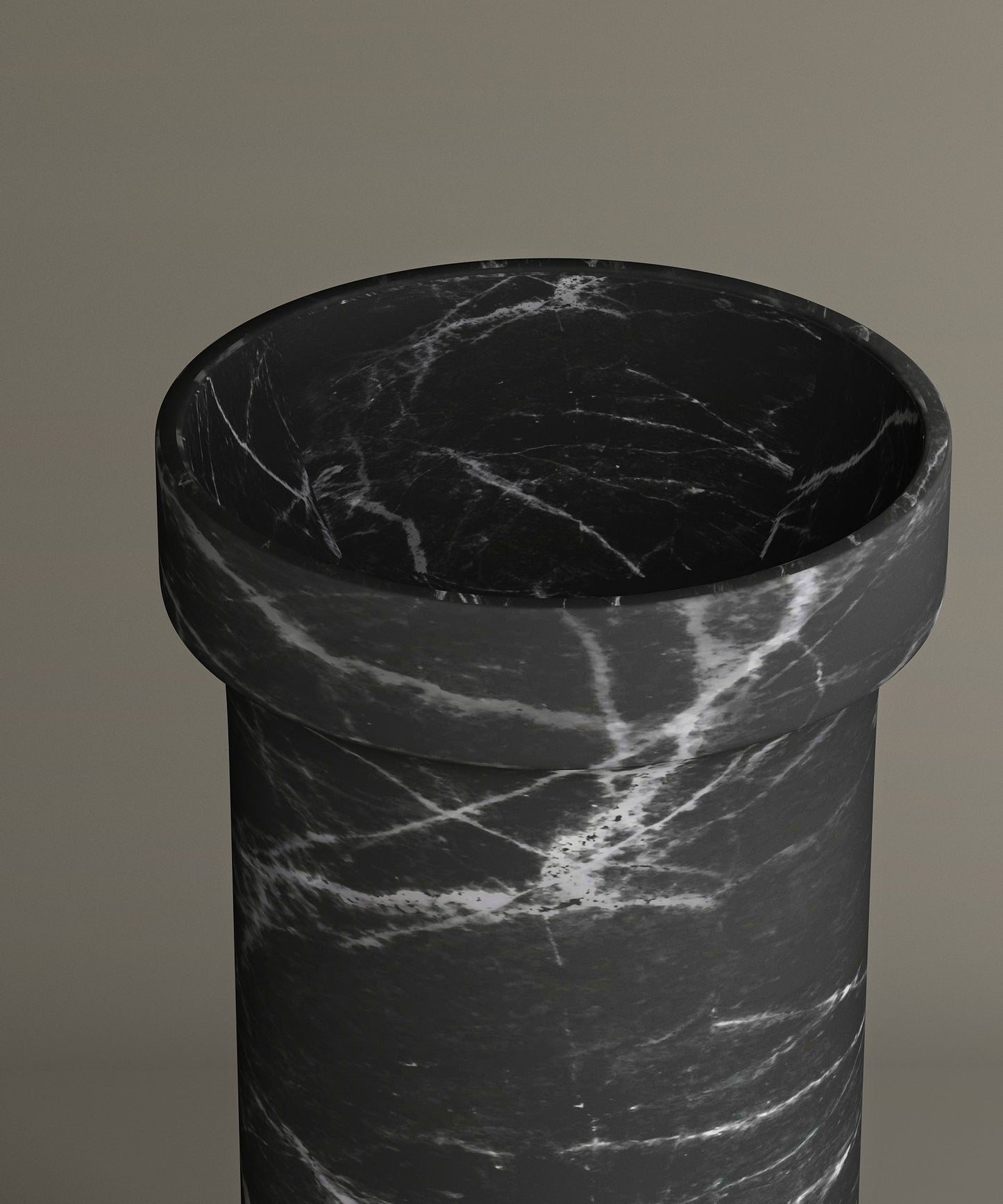 A close-up of the TRAVERTABLE Nero Marquina Marble Pedestal Vanity Sink, featuring bold white veining on black marbleβits sleek cylindrical form stands out against a taupe backdrop, adding modern luxury to any interior.