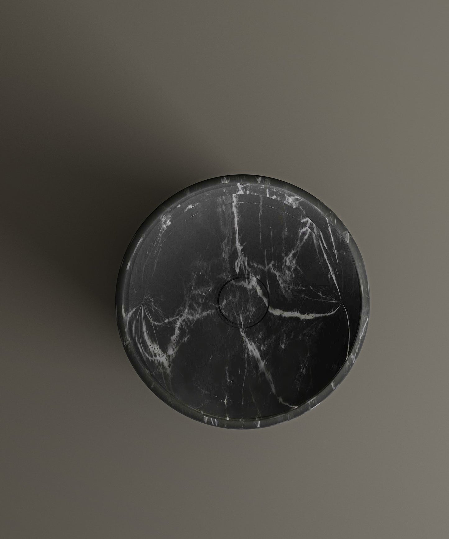 The TRAVERTABLE Nero Marquina Marble Pedestal Vanity Sink features bold white veining and a round design, mounted on a matte brown wallβan elegant focal point for modern interiors. Captured from above, its central drain ensures both style and function.