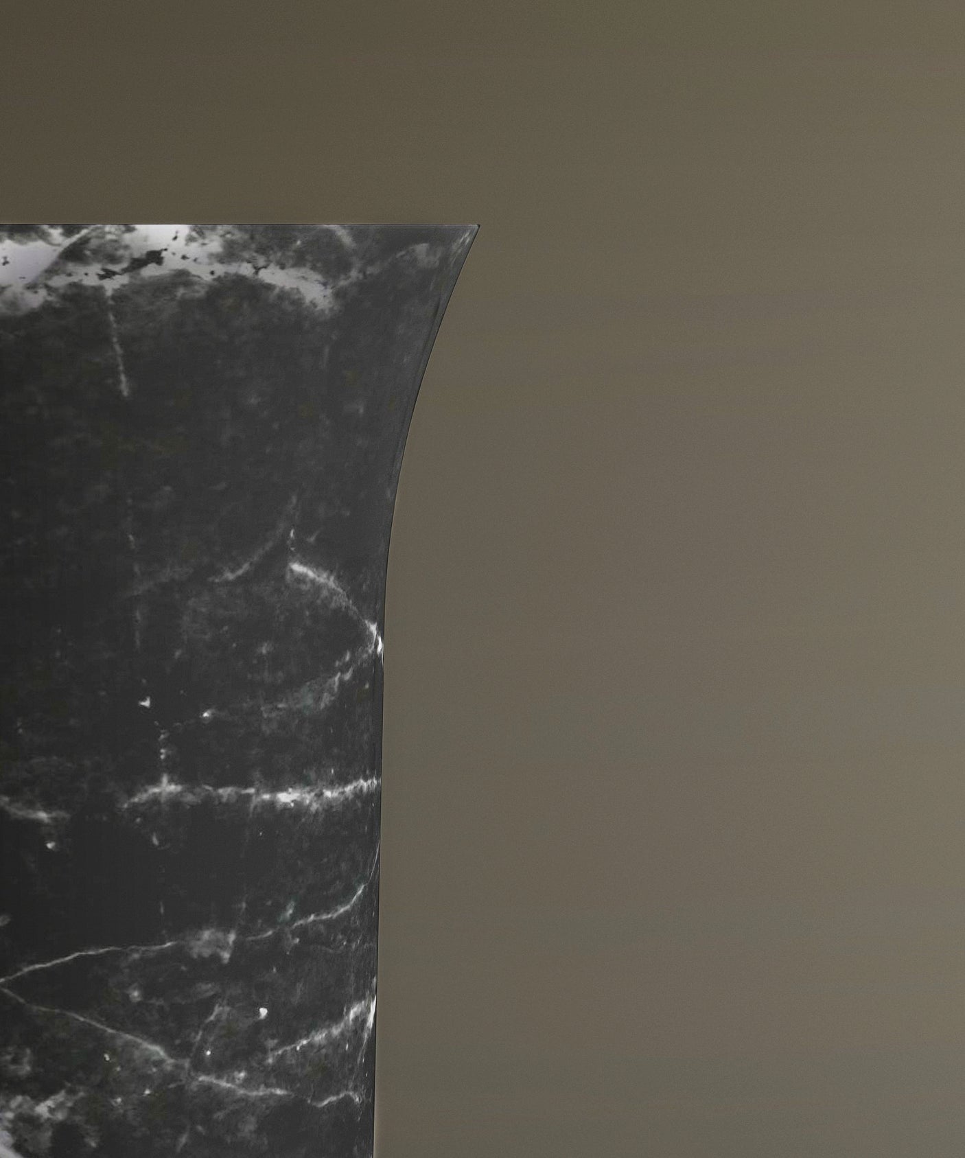 Close-up of the curved upper edge of the TRAVERTABLE Nero Marquina Marble Cylinder Pedestal Vanity Sink, featuring distinctive white veining and set against a light brown background for a sculptural effect.