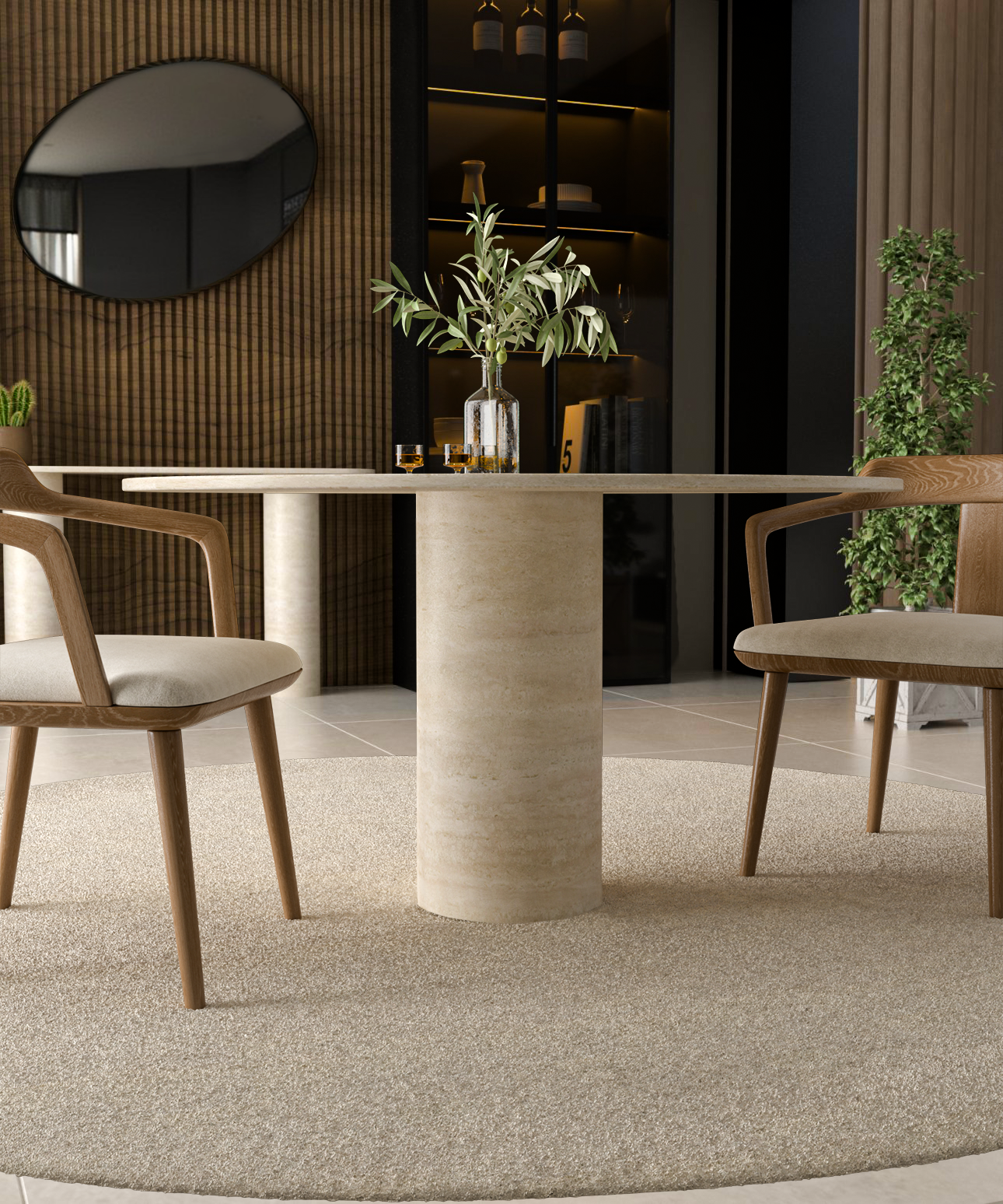 An Oval Travertine Dining Table with Cylindrical Center Base from TRAVERTABLE, paired with two light wood chairs featuring upholstered seats, and a glass vase with green branches on a circular beige rug in a modern dining area.
