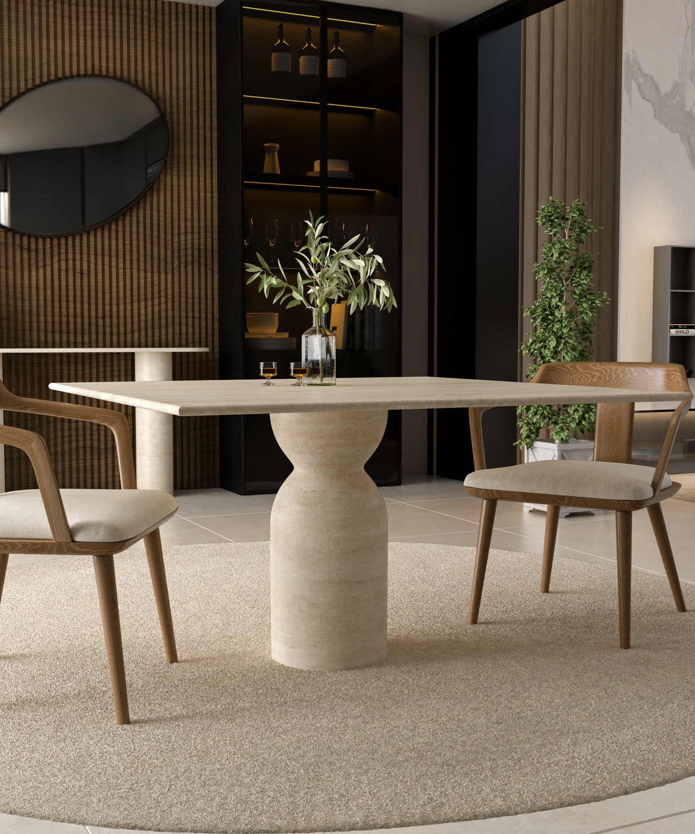A modern dining area showcases the TRAVERTABLE Square Travertine Dining Table with Sculptural Round Center Base, two wooden chairs with beige cushions, a round mirror on a wood-paneled wall, a plant, and shelves with bottles and glassware.