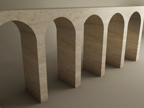 The TRAVERTABLE Travertine Console Table features five evenly spaced beige stone arches, casting elegant shadows against a plain background—a customizable piece that makes a grand architectural statement.