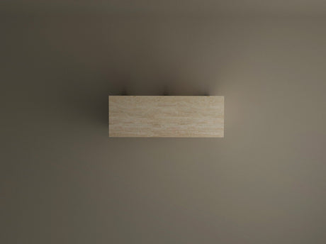 The Travertable Travertine Console Table with Two Arches stands out in solid stone atop a plain taupe wall, viewed from above. Its two delicate shadows emphasize the table’s customizable, modern elegance and architectural simplicity.