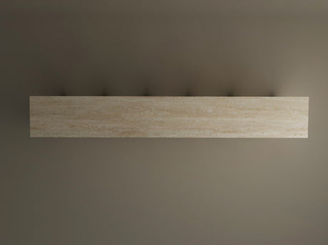 The TRAVERTABLE Travertine Console Table with Five Arches, a grand architectural statement, is mounted horizontally on a plain grey wall, its sculptural design casting subtle shadows and bringing customizable understated luxury to any space.