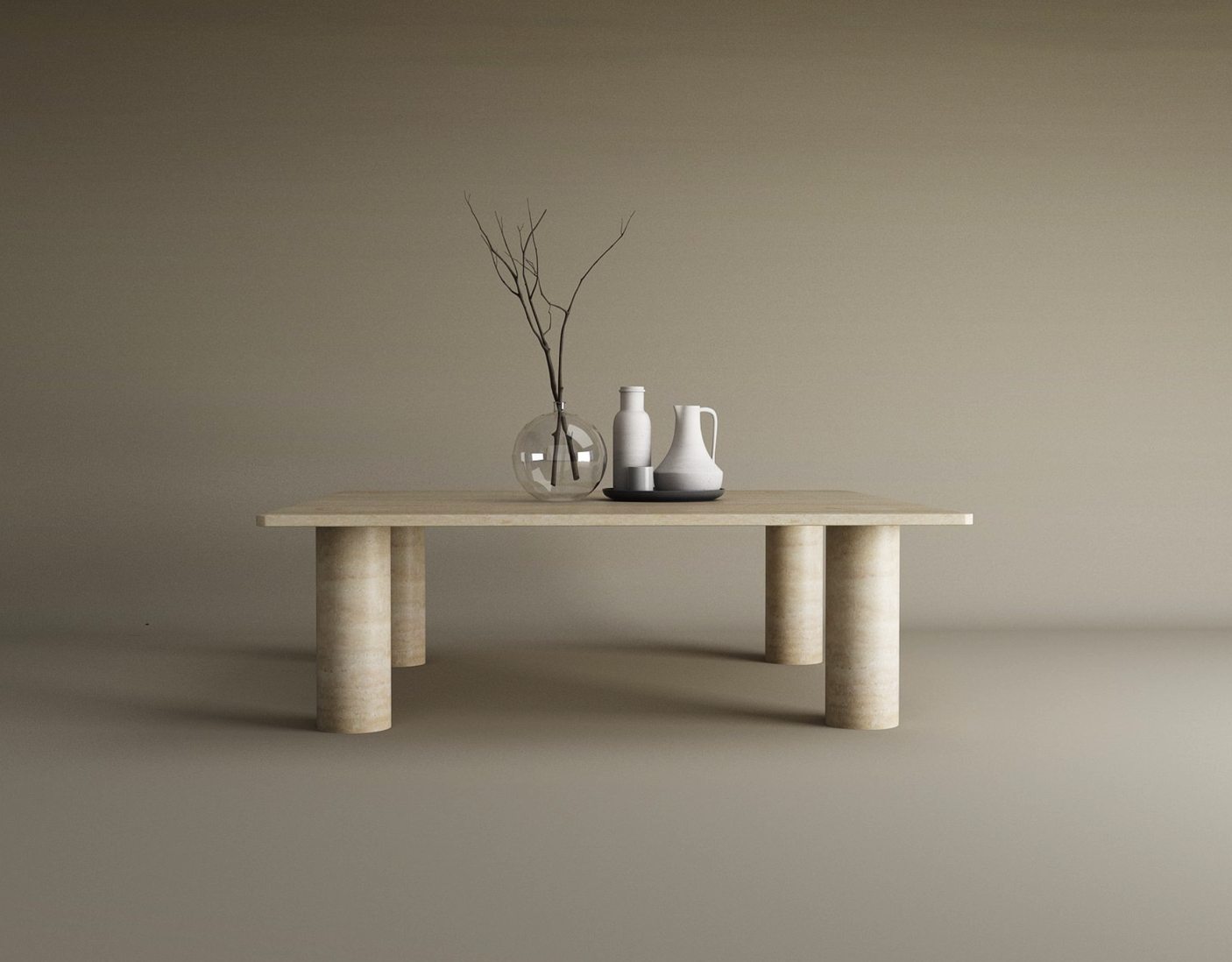 The TRAVERTABLE Square Travertine Coffee Table with a solid cylindrical base displays a glass vase with bare branches, a white ceramic pitcher, and a ceramic bottle, set against a plain beige background.