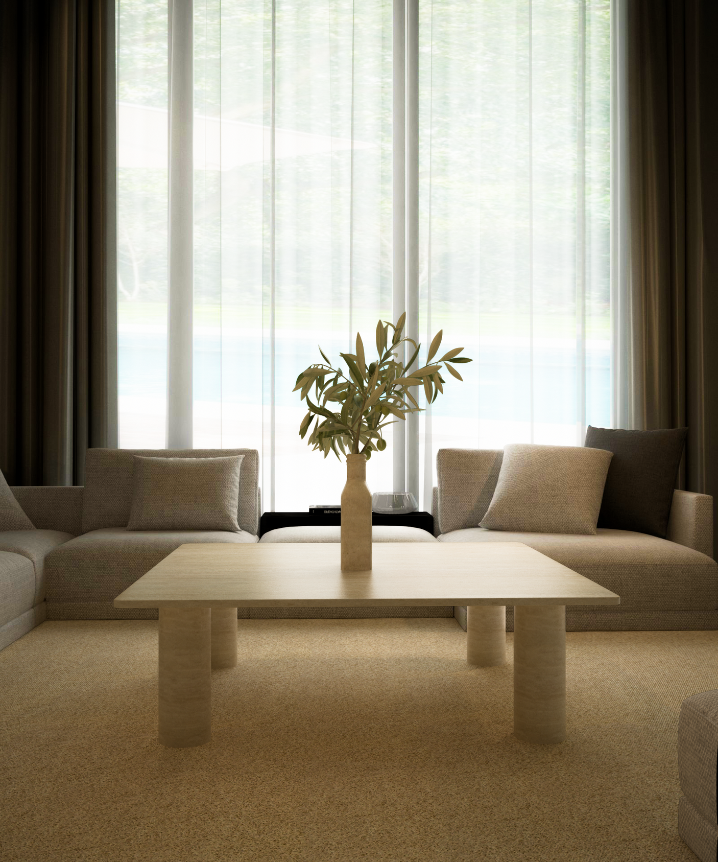 A modern living room featuring two beige sofas, the TRAVERTABLE Square Travertine Coffee Table with Solid Cylindrical Base, a vase with green branches, and large windows with sheer curtains overlooking greenery.