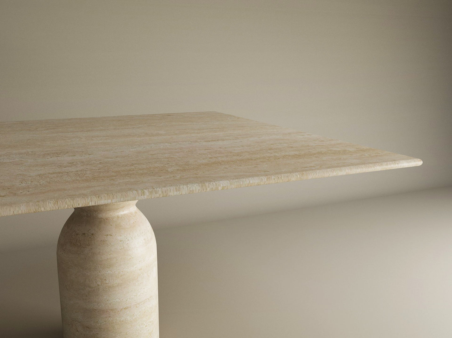 The TRAVERTABLE Square Travertine Dining Table features a smooth, light beige stone top and a sculptural round center base, shown partially against a neutral background to highlight its organic, timeless design. Customizable for your dining space.