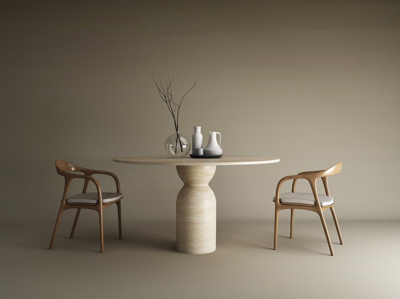 A TRAVERTABLE Oval Travertine Dining Table with a sculptural round center base sits between two wood chairs with white cushions; ceramic vases and a glass vase with branches accentuate the minimalist, elegant setting.