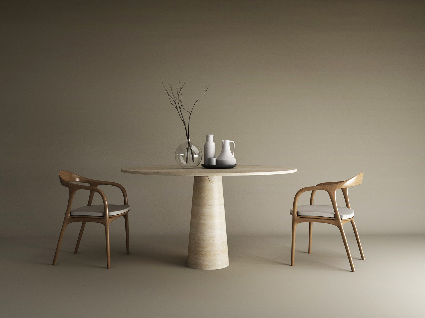 An oval natural travertine stone dining table by TRAVERTABLE with a conical base and two wooden chairs. On the tabletop: a clear vase with bare branches, a white jug, a gray jug, and a white cup, all against a beige background.