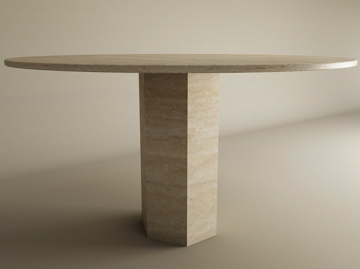 The TRAVERTABLE Oval Travertine Dining Table features a light stone top and unique hexagonal center base, blending geometric design with enduring craftsmanship. Customizable to fit minimal spaces with plain walls and floor.