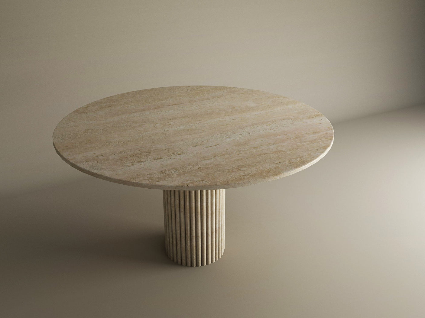 The TRAVERTABLE Oval Travertine Dining Table features a fluted round center base and solid beige stone, adding natural elegance and organic calm to a softly lit, neutral room. Customizable for your space.
