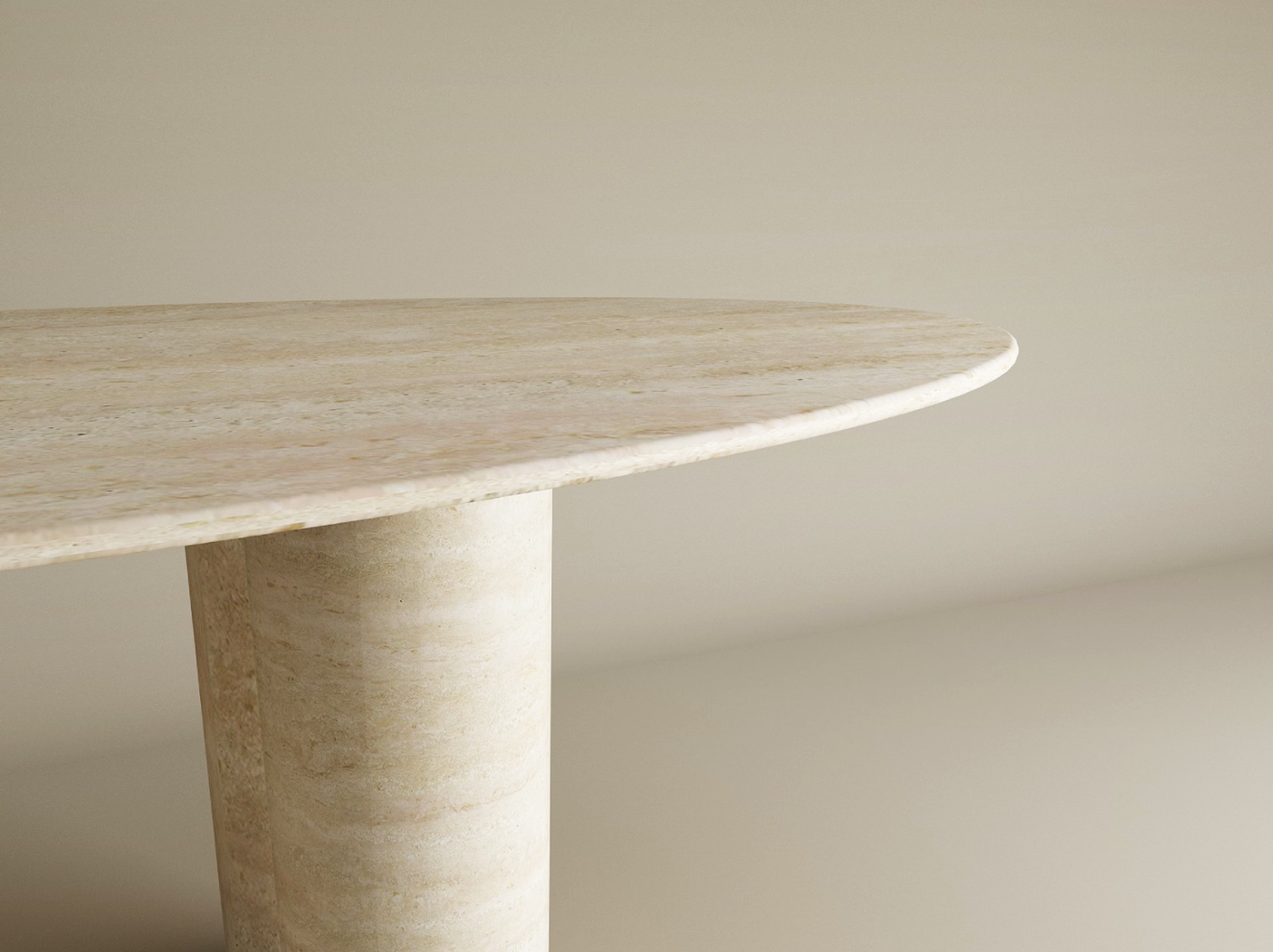 A close-up of the TRAVERTABLE Ellips Travertine Dining Table shows its light beige pure travertine tabletop and a cylindrical base against a neutral background, highlighting part of the customizable, heirloom-quality stone design.