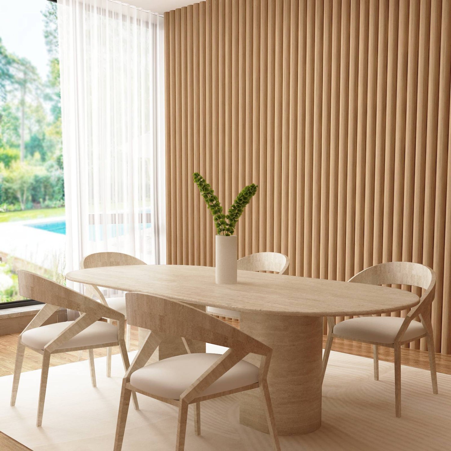 A modern dining room with a TRAVERTABLE Oval Travertine Dining Table featuring a sloped pedestal base, four matching chairs, white area rug, white vase with greenery, wood slat wall, and large window overlooking lush views.
