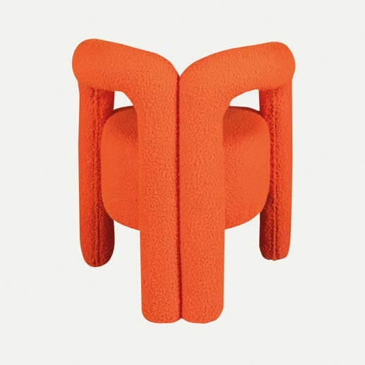 The Bold Bliss Lounge Chair by Travertable offers an artistic flair with vibrant orange fabric, a unique sculptural design, thick tubular legs, and a rounded backrest for ergonomic support and style.