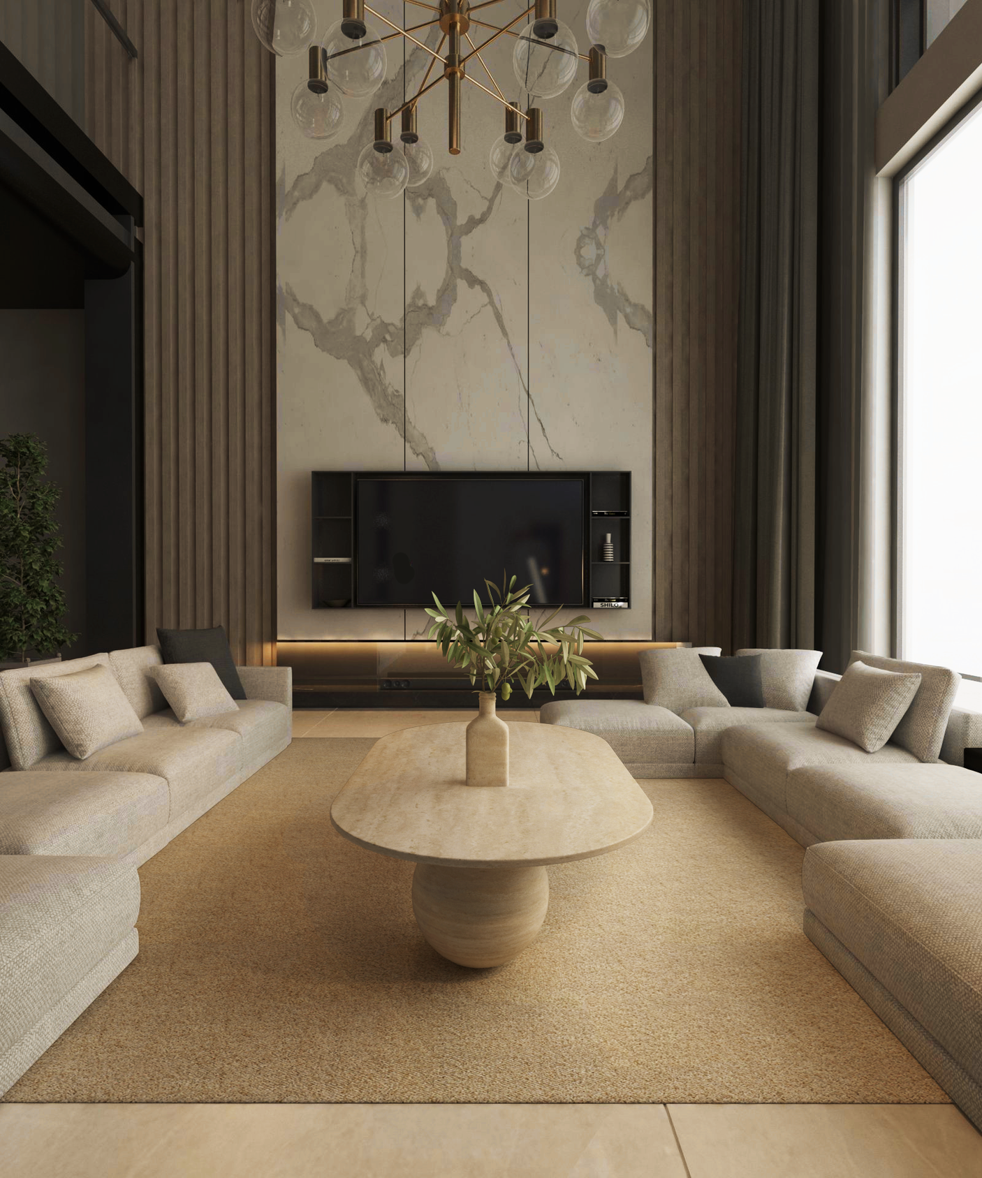 A modern living room features TRAVERTABLEs Oval Travertine Coffee Table with Stone Ball Base – Artistic Travertine – Customizable, surrounded by beige U-shaped sofas, a marble accent wall with TV, tall windows, and a gold chandelier under high ceilings.