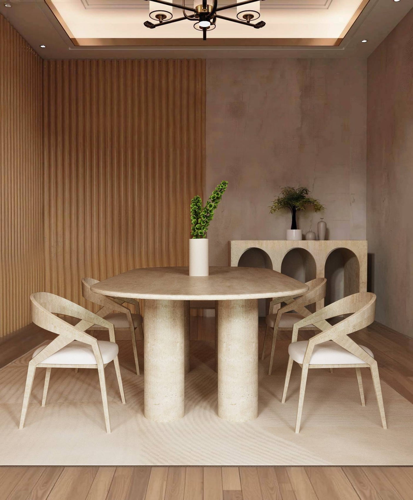 A modern dining room with the TRAVERTABLE Oval Travertine Dining Table featuring a pure travertine stone cylindrical base, four beige chairs, a white vase with green leaves, wood slat accent wall, sideboard decor, and neutral tones.