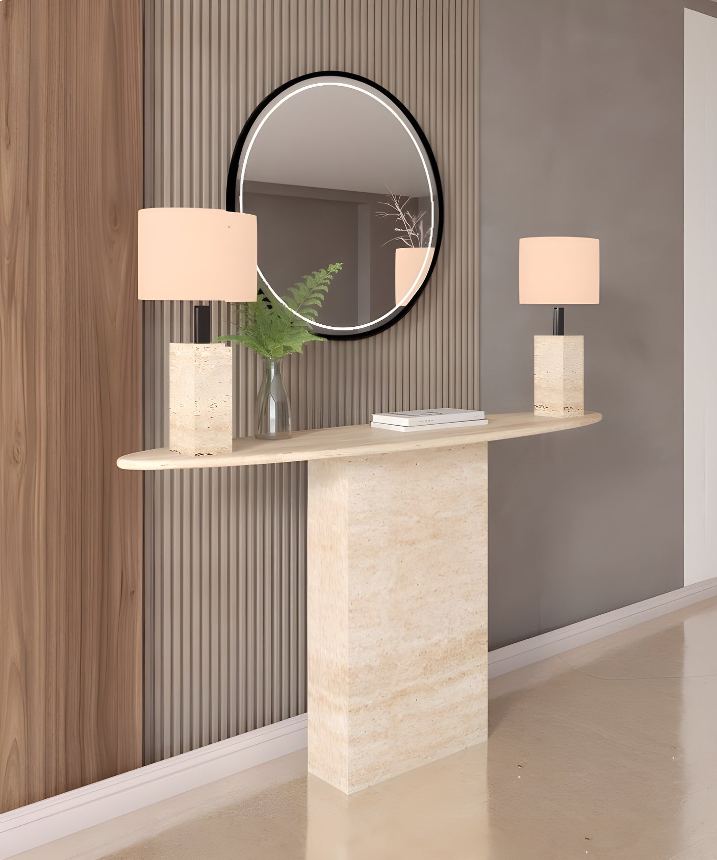 The TRAVERTABLE Ellips Travertine Console Table with Block Base features natural stone elegance, adorned with two square stone-based lamps, a vase of green ferns, and a book, set before a round mirror against a light striped wall.