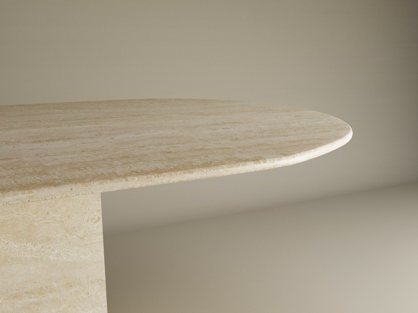A close-up of the TRAVERTABLE Oval Travertine Dining Table features a smooth natural stone tabletop and block base, set against a neutral background. This customizable dining table combines timeless elegance with modern design.