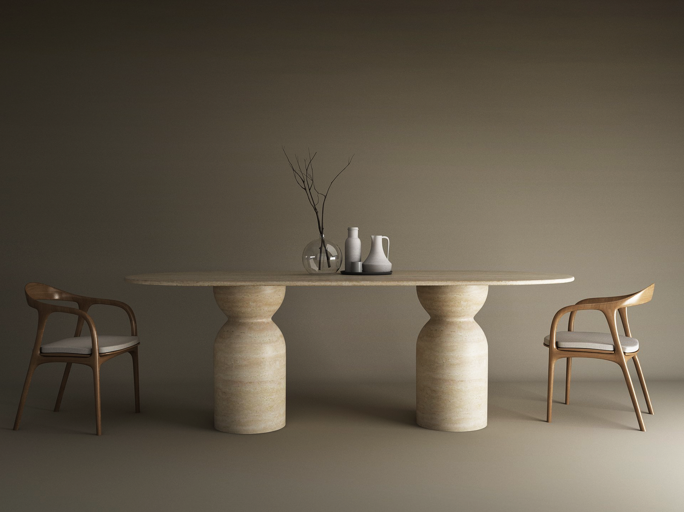 The TRAVERTABLE Oval Travertine Dining Table with Sculptural Round Base features a natural stone top, styled with minimalist vases and a dried branch. Two wooden chairs with white cushions sit on either side, set against a plain brown background.