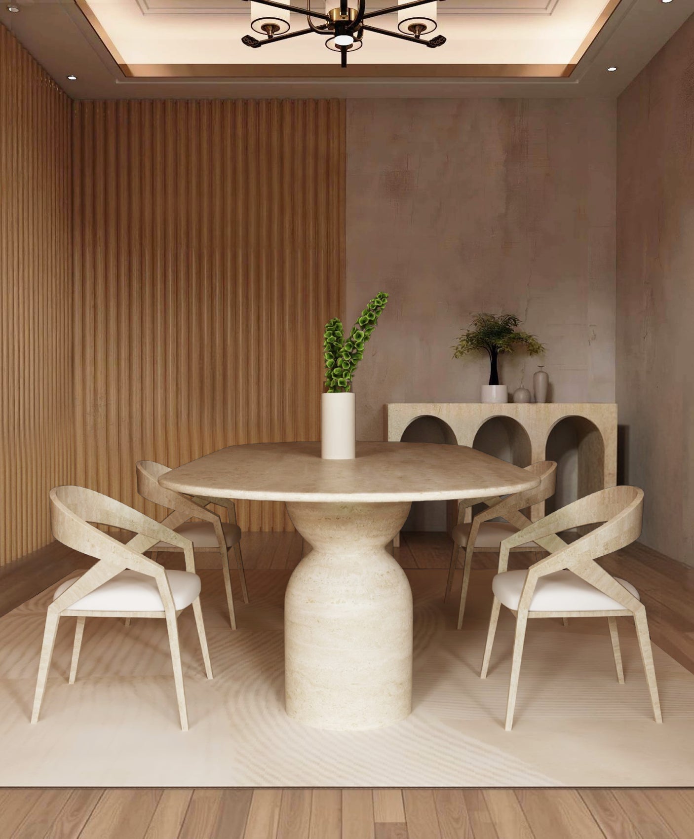 A modern dining room with the TRAVERTABLE Oval Travertine Dining Table featuring a sculptural round stone base, paired with four light wood cross-back chairs, a white vase with green leaves, and a console displaying decorative objects against a textured wall.