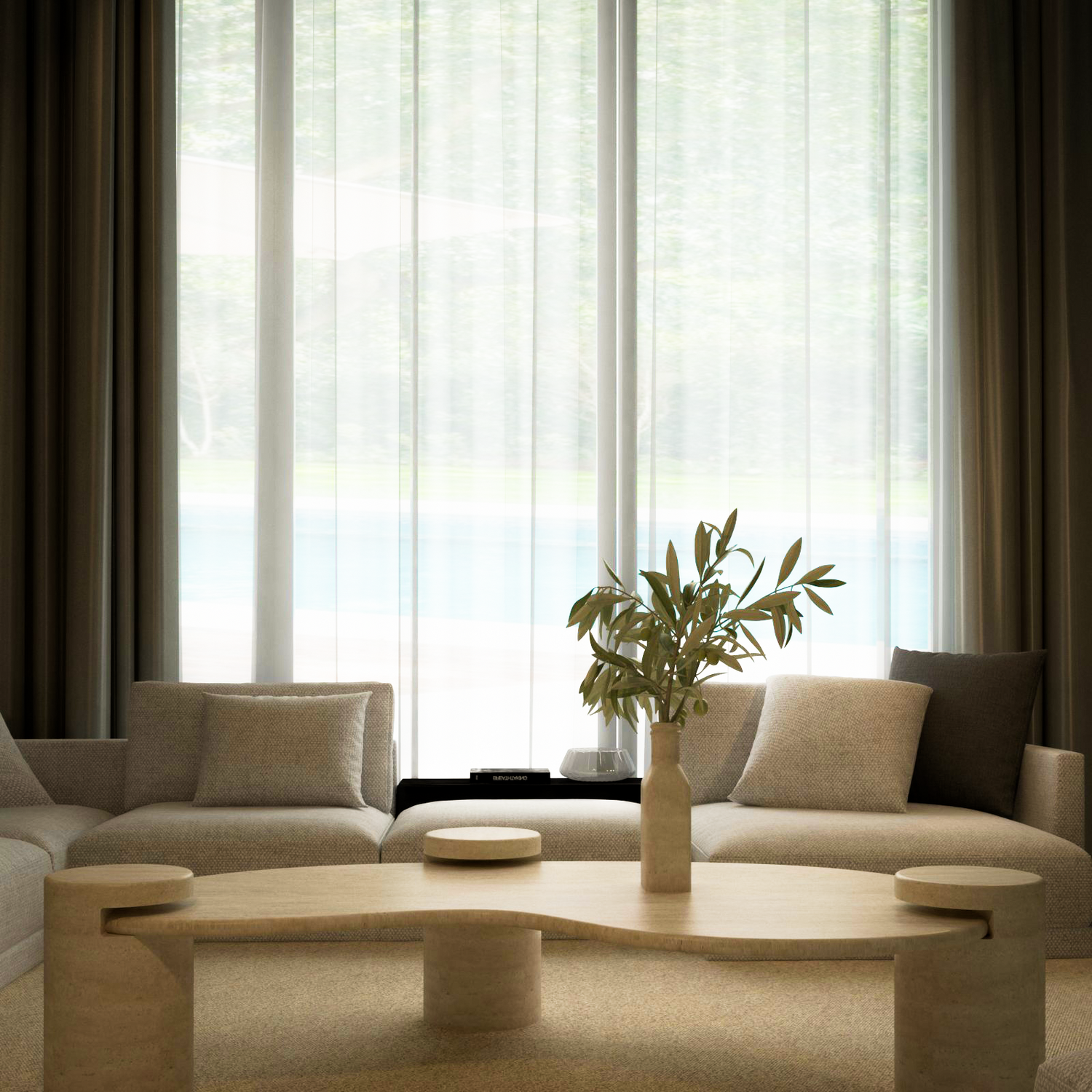 A modern living room features cream sofas, grey cushions, and the TRAVERTABLE Wavy Travertine Coffee Table with Cylindrical Base – Organic Flow, topped with a ceramic vase of leafy branches. Sheer curtains on tall windows let in soft light and reveal lush greenery outside.