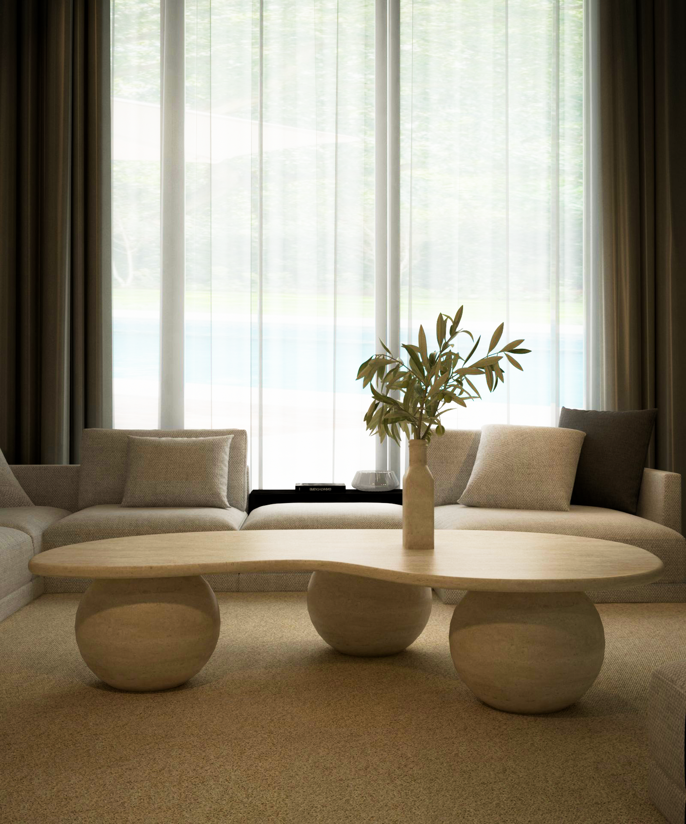A modern living room features beige sofas and the TRAVERTABLE Wavy Travertine Coffee Table with Stone Ball Base—an organic, customizable piece topped with a vase of green branches. Sheer white curtains fill the minimalist space with soft natural light.