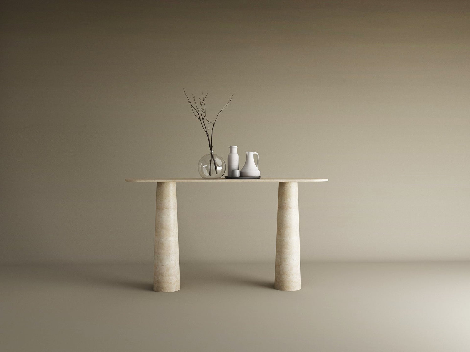 The Ovale Travertine Console Table by TRAVERTABLE features an organic travertine stone top and conical pedestal base. Three ceramic vases—one transparent, two opaque—with bare branches sit against a plain beige background.