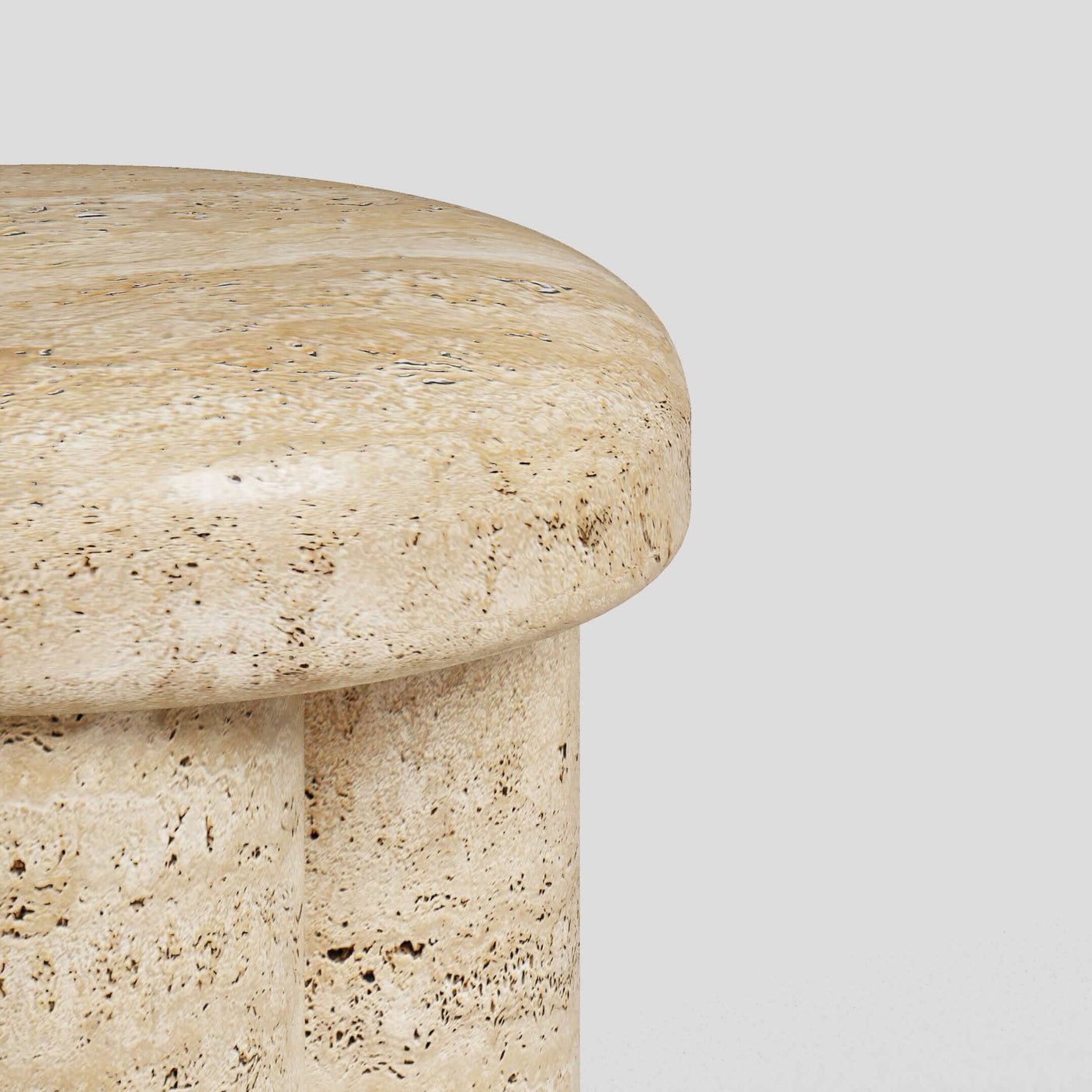 A detailed shot of Travertables Travertine Elegance Accent Table showcases its smooth, polished beige surface and natural variations in texture and color against a white background.