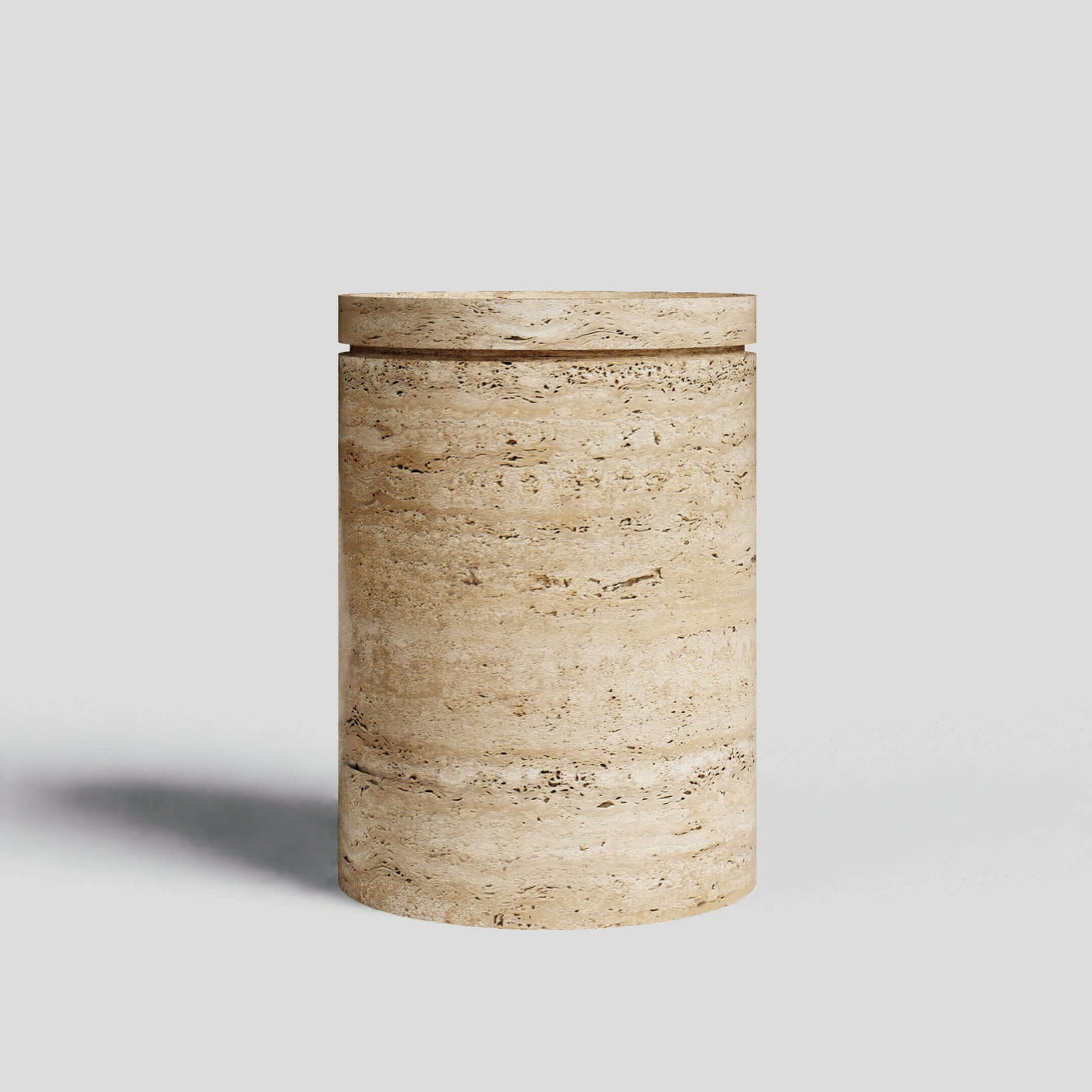 The Travertable Cycladic Secret is a cylindrical stone end table with a smooth, natural light travertine texture and a fitted lid. It sits on a plain white background, offering minimalist and neutral aesthetics with hidden storage.