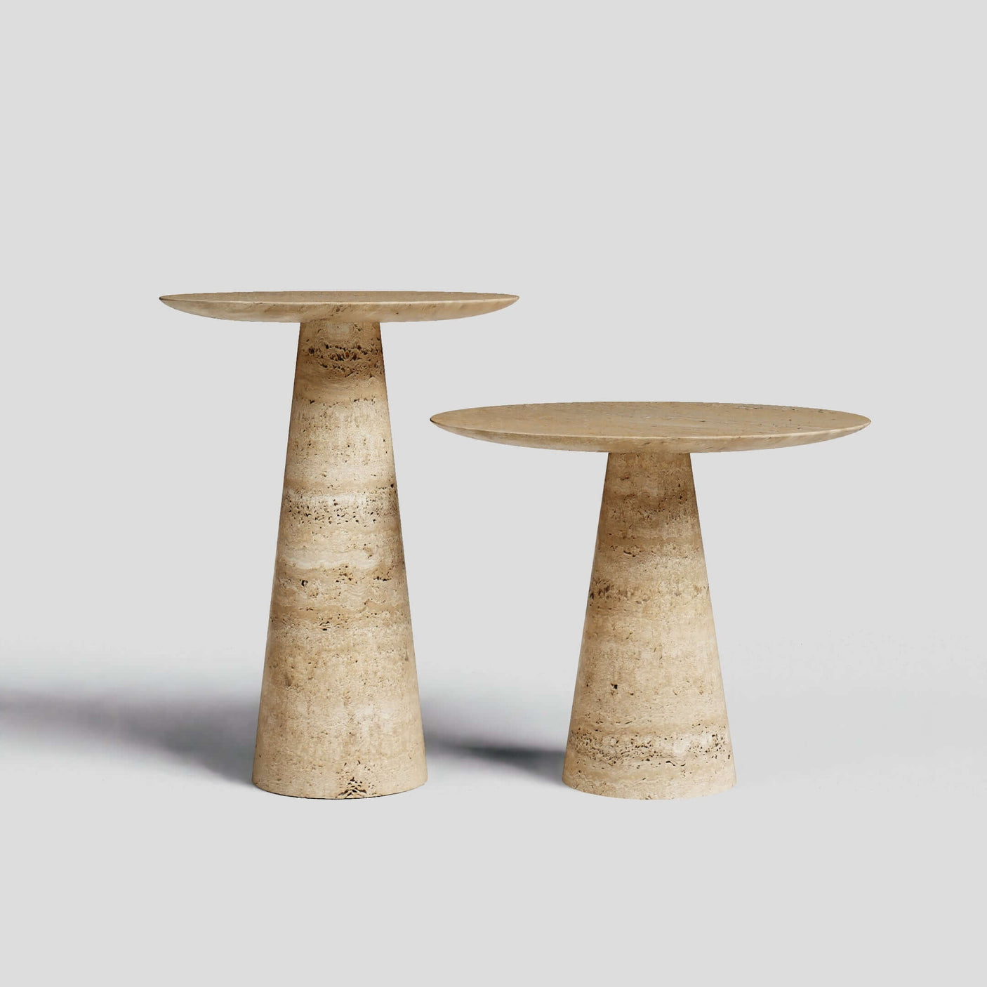 The Twin Pillars Travertine Side Table Set by Travertable exudes natural elegance against a gray backdrop, showcasing round tops with conical bases in beige and brown marble; one table is gracefully taller than the other.