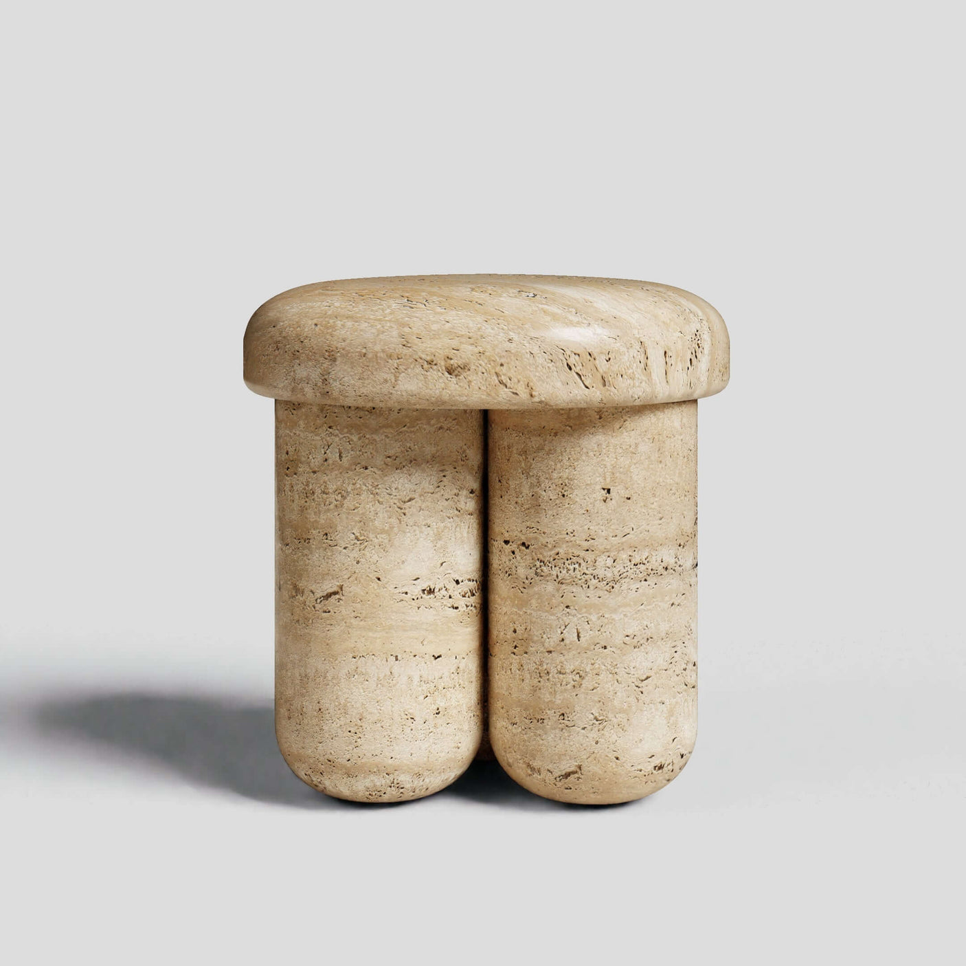 The Travertine Elegance Accent Table by Travertable features a beige travertine design with a smooth, rounded seat on cylindrical legs. Its minimalistic, sculptural look makes it a chic addition to any setting, set elegantly against a plain gray background.