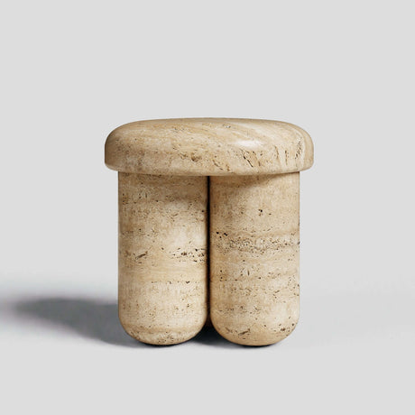 The Travertine Elegance Accent Table by Travertable features a beige travertine design with a smooth, rounded seat on cylindrical legs. Its minimalistic, sculptural look makes it a chic addition to any setting, set elegantly against a plain gray background.