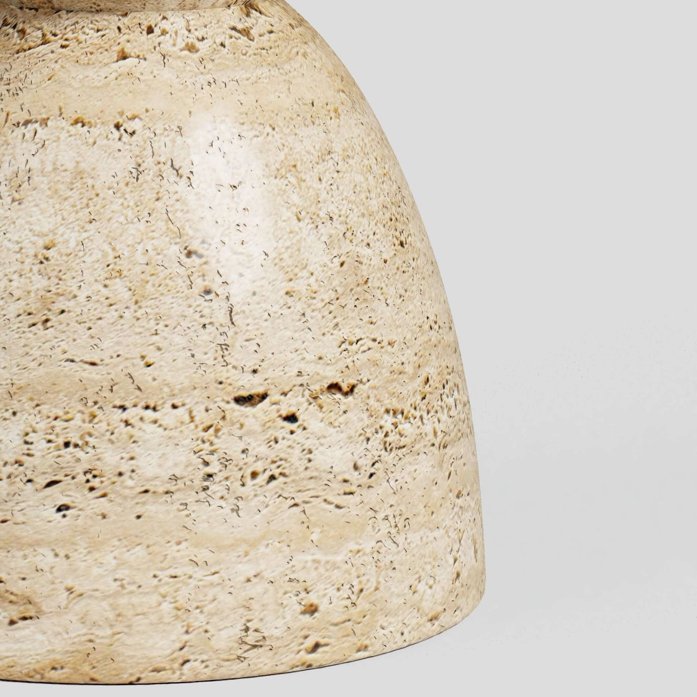 The Eda Beige Travertine Sphere Table by Travertable is a smooth, rounded statement piece in solid stone, featuring natural speckled patterns against a light gray background.