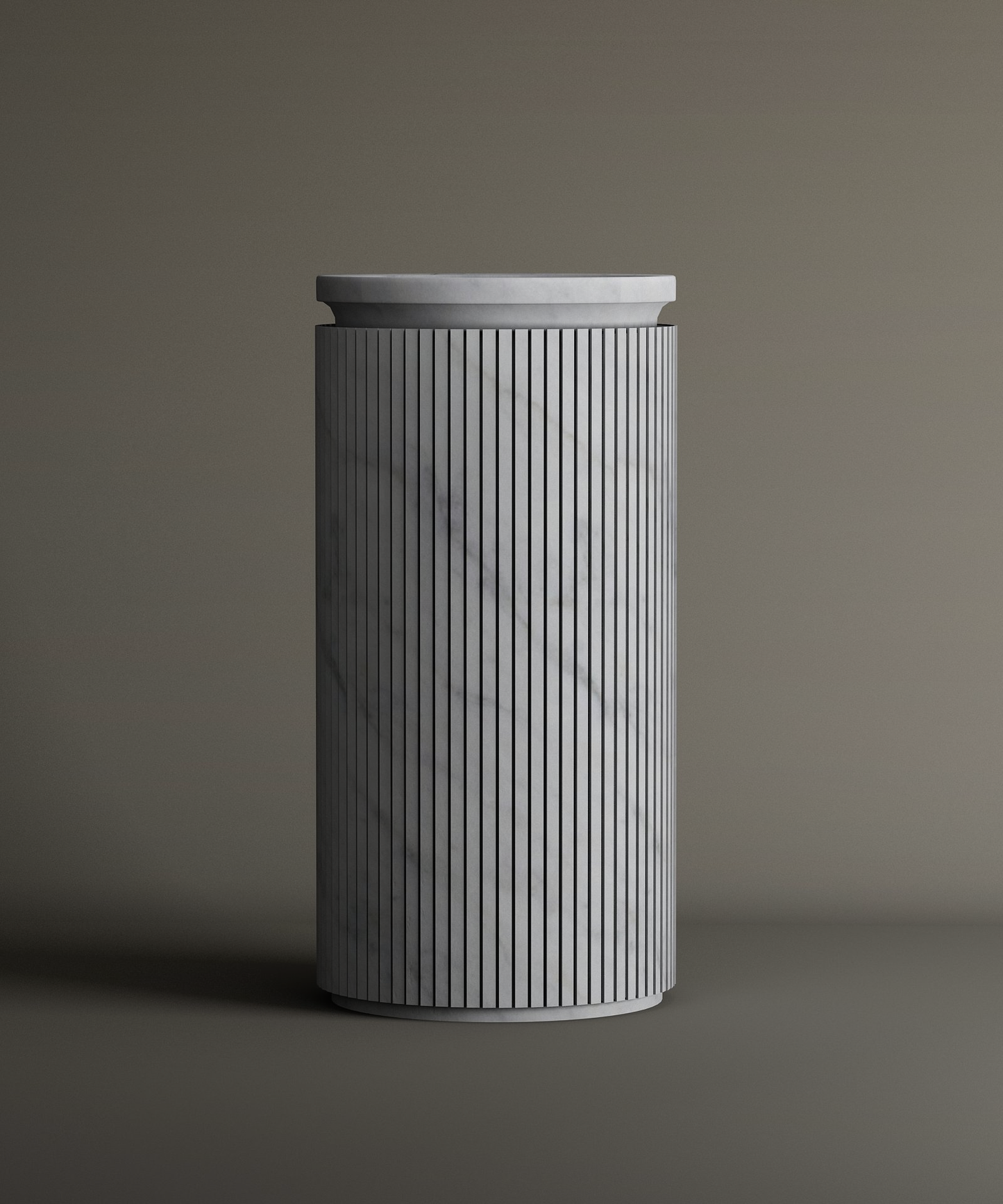 The TRAVERTABLE Carrara Round Marble Pedestal Vanity Sink features a tall, cylindrical form with vertical grooves and smooth Carrara marble surface, highlighted by subtle gray veining against a neutral background.