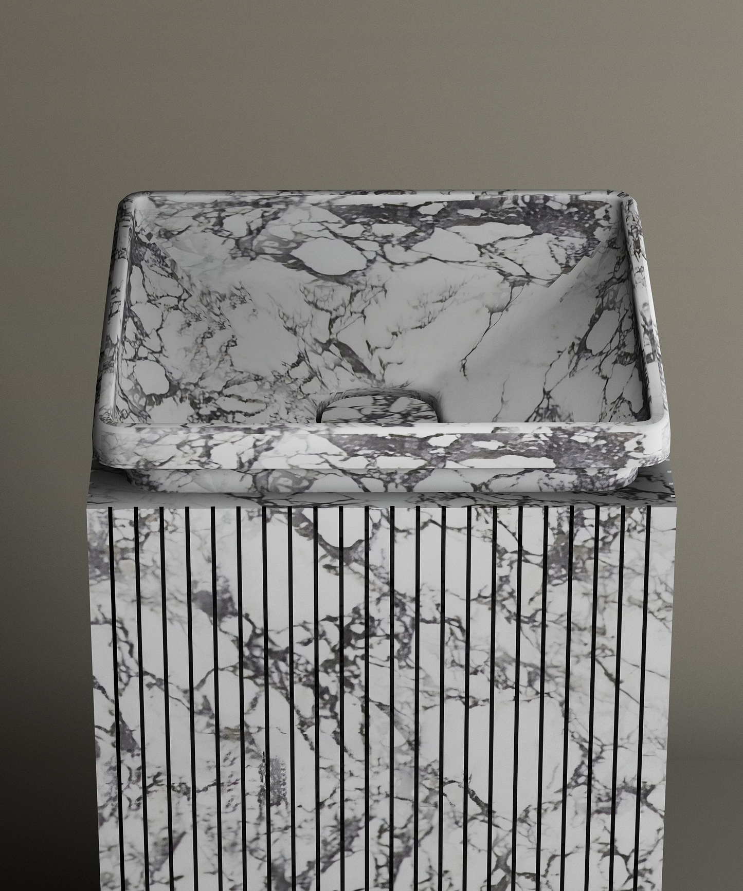 The TRAVERTABLE Calacatta Square Marble Pedestal Vanity Sink, with gray and black veining and vertical grooves, creates a bold marble centerpiece against a plain gray background.