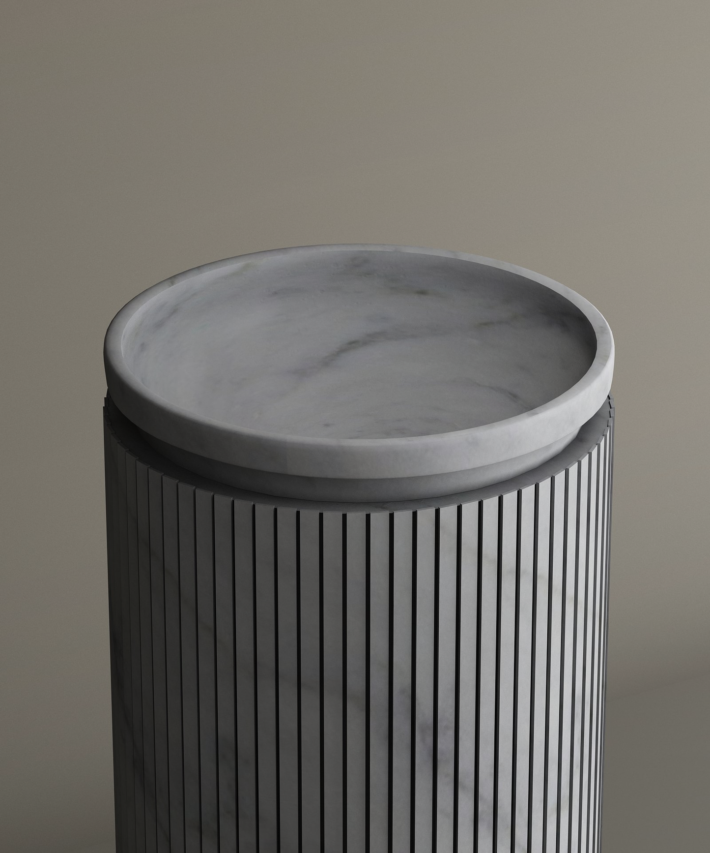 The TRAVERTABLE Carrara Round Marble Pedestal Vanity Sink features a smooth gray marble tray atop a grooved cylindrical pedestal, evoking refined Italian bathroom elegance against a simple beige backdrop.