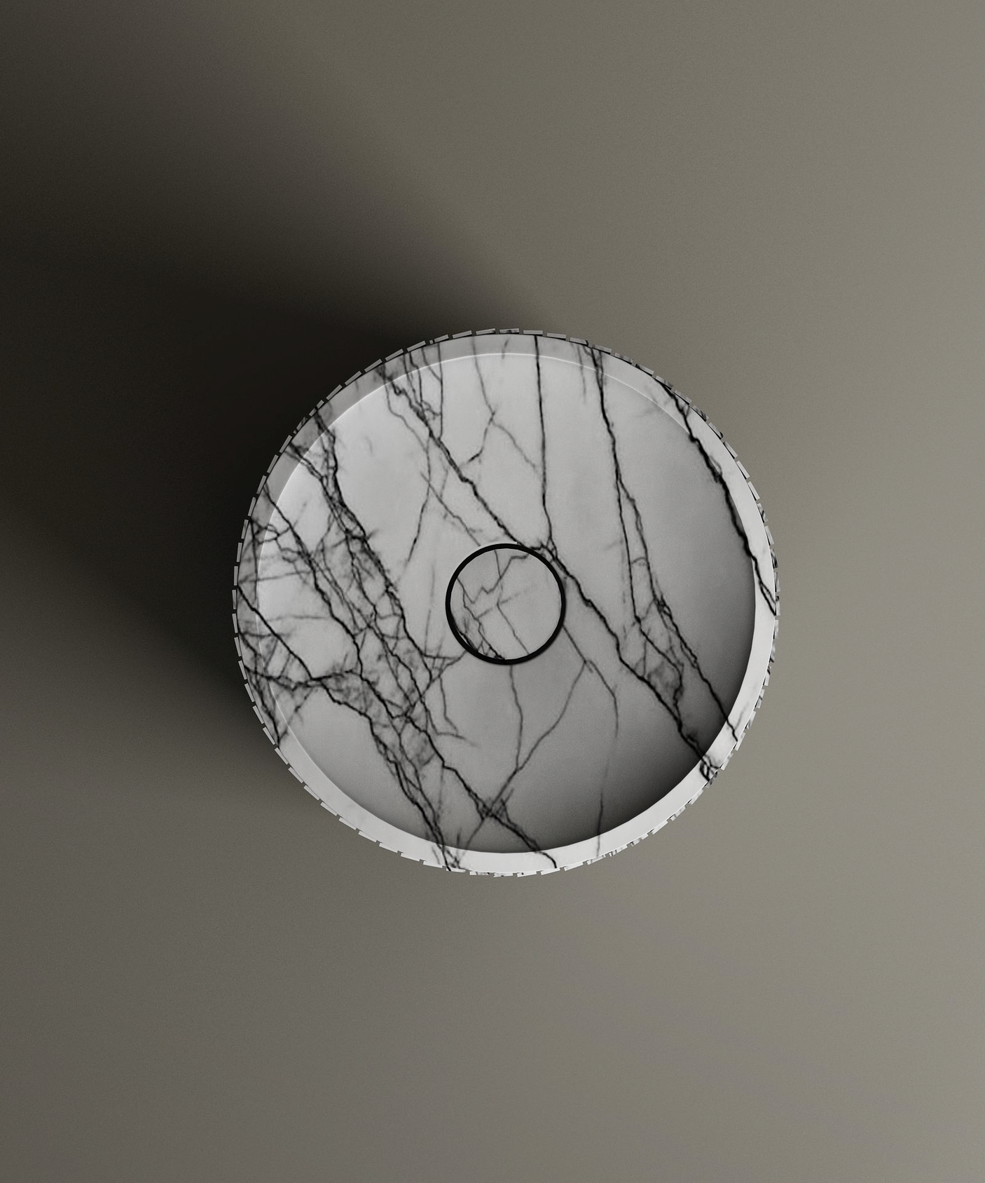 The Lilac Round Fluted Marble Pedestal Vanity Sink by TRAVERTABLE, seen from above on a taupe background, features white marble with dark gray veining, a central drain, and casts a shadow to the left.