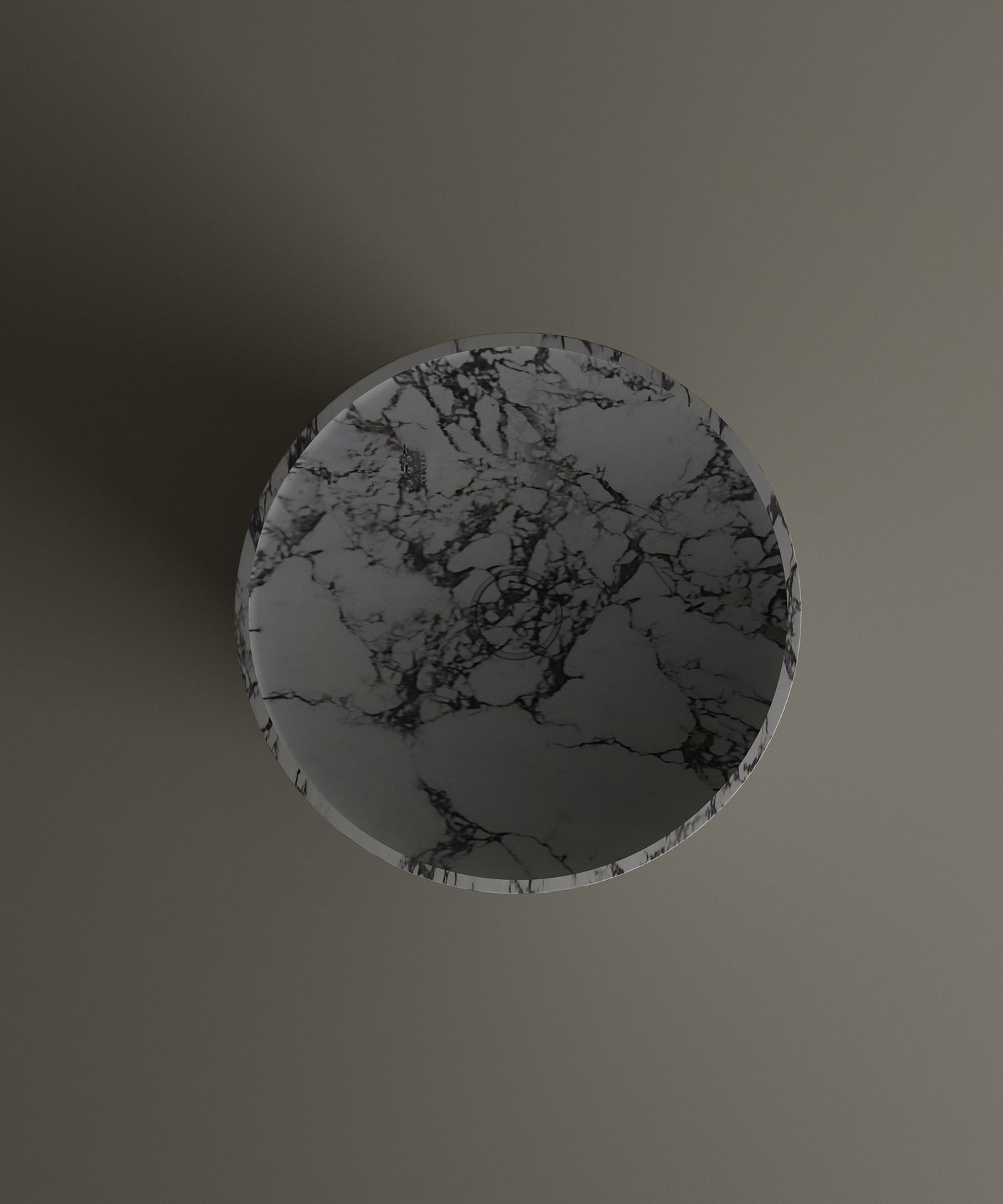 The TRAVERTABLE Calacatta Marble Cylinder Pedestal Vanity Sink, featuring a striking black and white marble pattern, is centered on a smooth taupe surface, casting a subtle left shadow in this overhead shot.