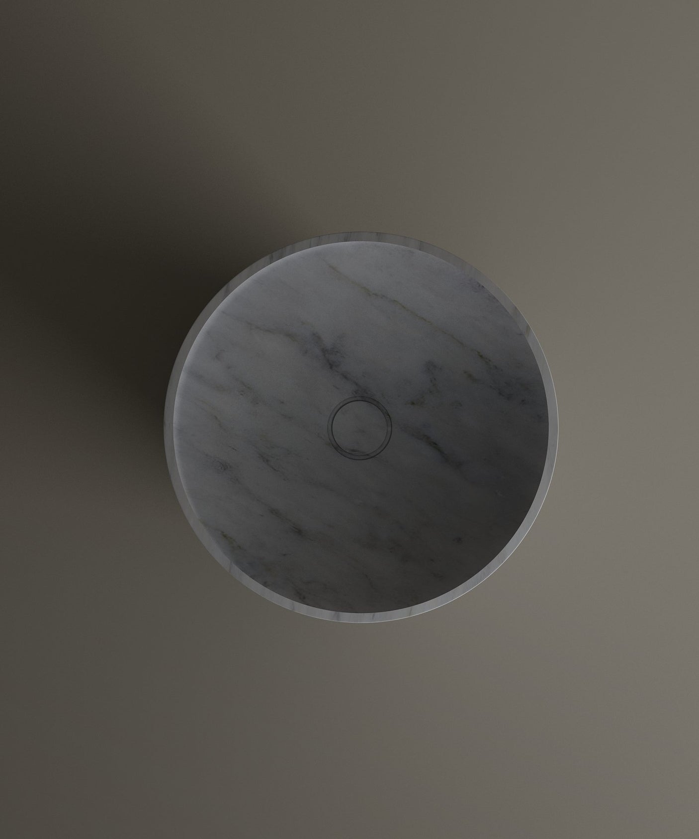 The TRAVERTABLE Carrara Marble Cylinder Pedestal Vanity Sink is displayed from above on a neutral background, showcasing its round gray bowl, subtle veined pattern, and central circular drain.