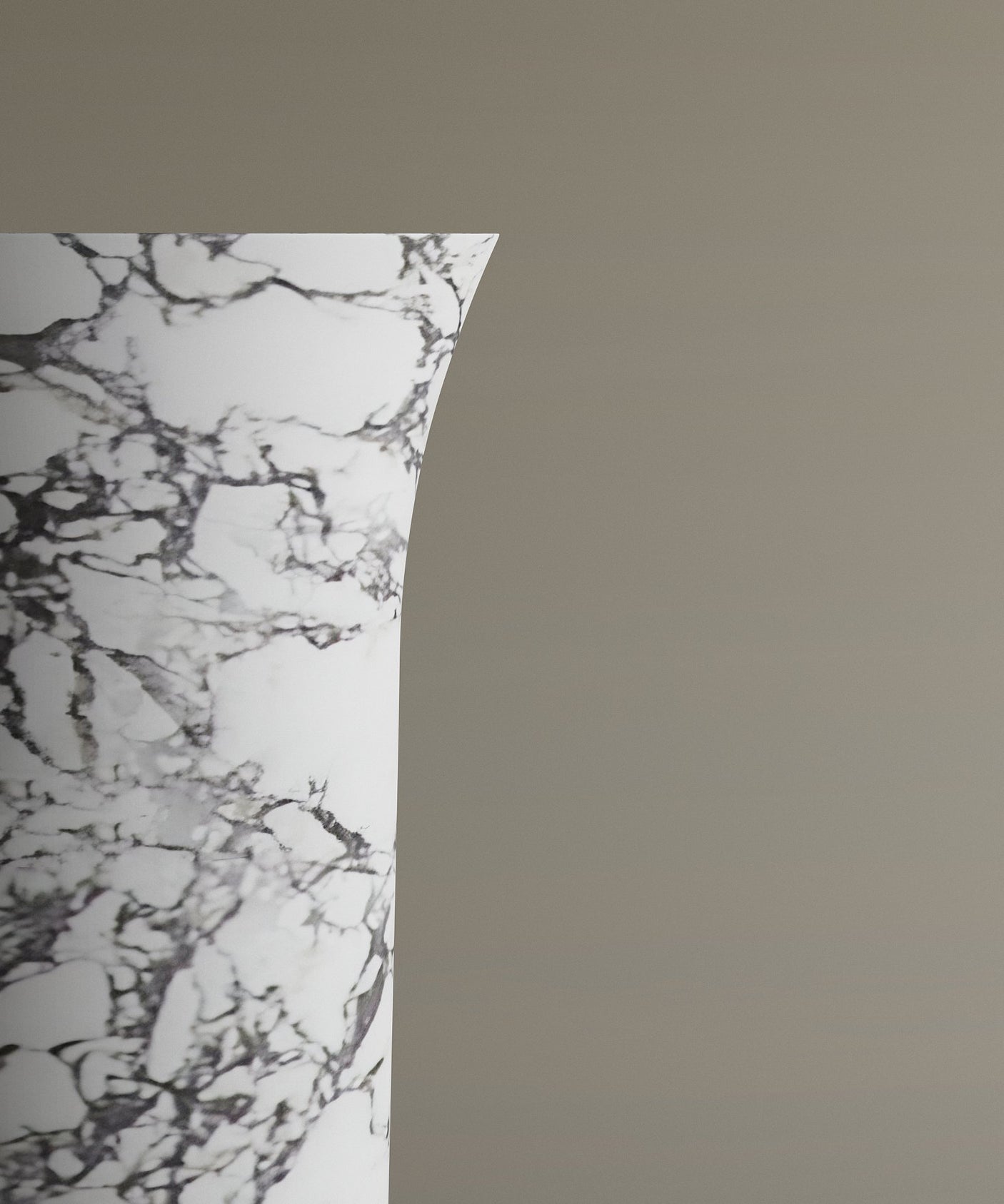 A close-up of the top left of the TRAVERTABLE Calacatta Marble Cylinder Pedestal Vanity Sink, featuring marble-like white and gray veins, is shown against a plain taupe background, with only part of this statement piece visible.