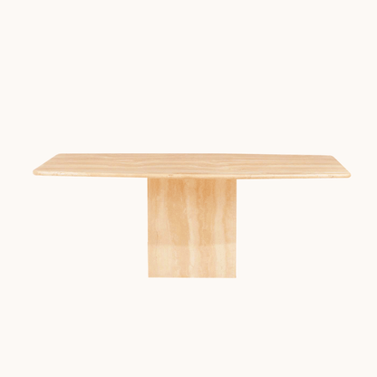 The Travertable Serenity Travertine Dining Table features a rectangular wooden surface with a pedestal base against a white backdrop. Its light wood grain enhances the premium travertine elements, offering an elegant and minimalist look.