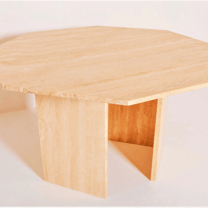 The Harmony Travertine Dining Table by Travertable is a contemporary, large octagonal table crafted from light-colored wood. It features a minimalist design with a flat top and two angled, sturdy wide legs, set against a plain white background.