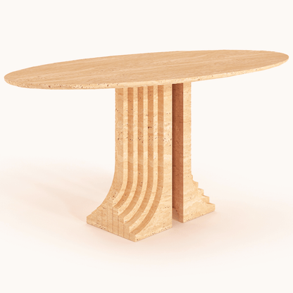 The Aurora Travertine Dining Table by Travertable boasts an elegant oval wooden design with an architectural base of stacked, vertically-aligned segments. Its light natural wood finish and customization options enhance its stylish, modern aesthetic for a personalized touch.