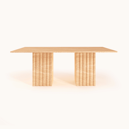 The Ridge Rectangular Travertine Dining Table by Travertable exudes modern sophistication with its smooth surface and two wide, fluted legs. Its natural wood grain-like travertine texture and minimalist design stand out against a plain white background.